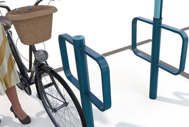 Teal metal bicycle parking rack with a vintage cruiser bike and wicker basket in an urban setting.