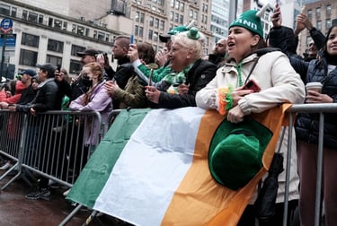 Crowds celebrate St. Patrick's Day in New York City with an Irish flag and green festive hats.