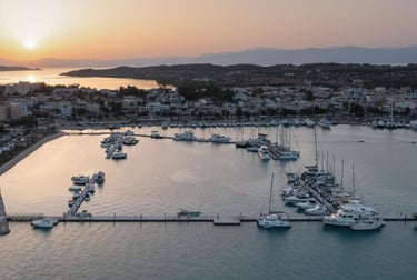 Aerial view of luxury yachts and sailboats moored in a Mediterranean marina at sunset.