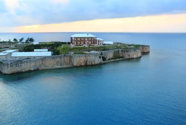 Historical Royal Naval Dockyard fortress overlooking the blue ocean at sunset in Bermuda.