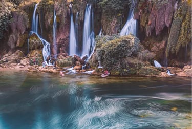 Scenic view of Kravica Waterfall in Bosnia with cascading water and a turquoise lake.