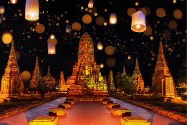Glowing paper lanterns floating over the ancient Buddhist temples of Ayutthaya, Thailand at night.