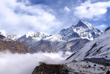 Snow-capped peaks of the Himalayas above a thick layer of clouds at Annapurna Base Camp in Nepal.