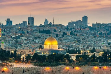 The golden Dome of the Rock stands out against the Jerusalem skyline during a purple sunset.