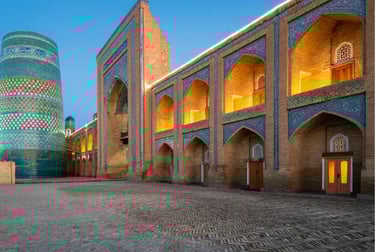 Illuminated ancient architecture of Itchan Kala in Khiva Uzbekistan featuring the Kalta Minor Minaret.