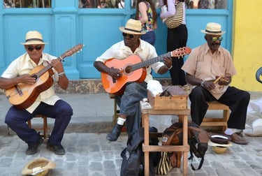 Traditional Cuban street musicians in straw hats playing guitars and percussion in Old Havana.