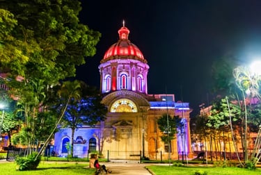 The National Pantheon of Heroes in Asuncion, Paraguay, illuminated with vibrant colors at night.
