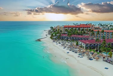 Aerial view of a luxury Caribbean beach resort in Aruba with turquoise water and white sand.