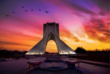 Azadi Tower monument in Tehran, Iran at sunset with a vibrant purple and orange sky and birds flying.