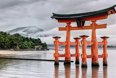 The iconic orange Great Torri Gate of Itsukushima Shrine in Miyajima, Japan, on a misty day.