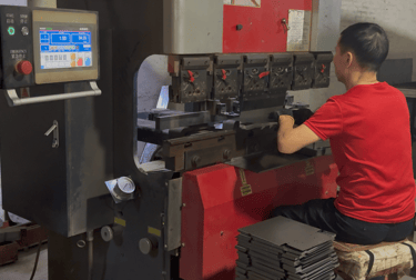 ClaraTech factory: Technicians using a bending machine for custom industrial monitor metal enclosures.