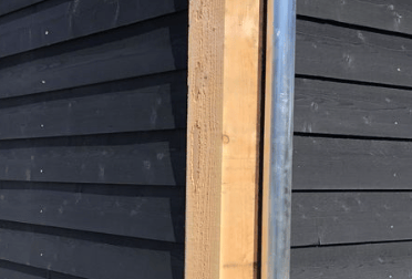 Un mur en bois suite à la fabrication d'une peinture suedoise noir