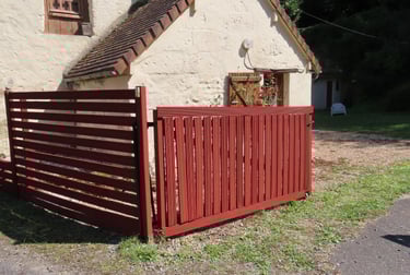 Application d’une peinture naturelle sur une clôture bois pour une protection durable et écologique.
