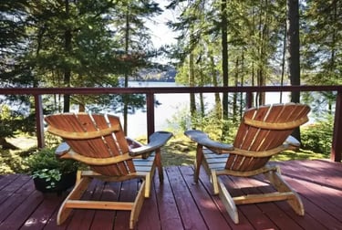 Deux chaises sur une terrasse face à un lac boisé, illustrant la gestion du changement en hôtellerie