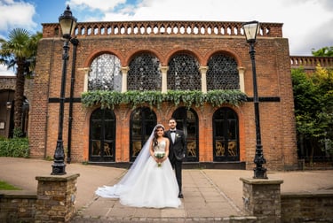 Bride and groom standing in front of a historic brick building, captured by Fred Art Studio.