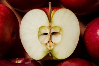 Fresh red apples with one sliced open showing the white core and seeds.
