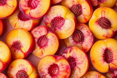 A colorful top-down view of fresh sliced peaches showing yellow flesh and red pits.