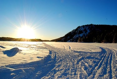 snow on a frozen lake with the sun on the horizon-flikr cite