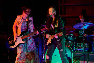 Actress Sofia Skates, Sophia Chapdelaine and Tristan Miura play music in a scene of Lupe Q Corn Cake