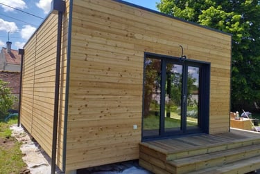 une maisonette ne cube avec un bardage bois avant peinture bois brut sapin