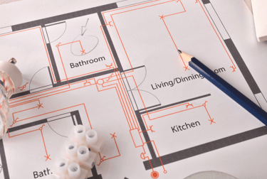 Residential electrical blueprint with pencil and wiring connectors for home renovation planning.