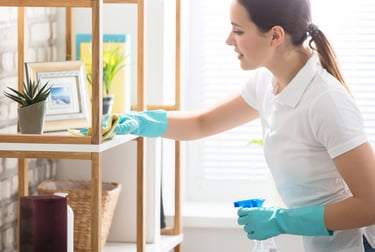 a house cleaner in a white shirt and gloves cleaning in Laguna Beach