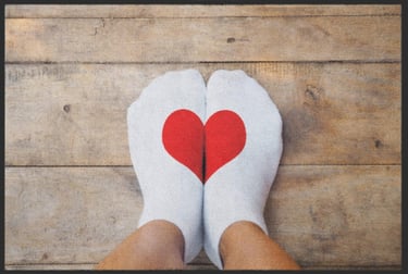 a person's feet in white socks with a red heart