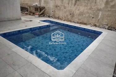 Desain kolam renang dengan sentuhan batu alam, menyoroti tekstur dan warna.