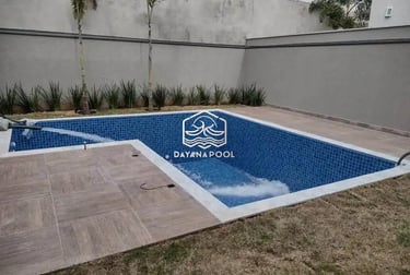 Proses pemasangan material finishing mozaik pada dinding kolam renang oleh tukang berpengalaman.