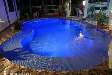 Pemandangan kolam renang yang tenang di malam hari, menciptakan suasana oase di perkotaan.