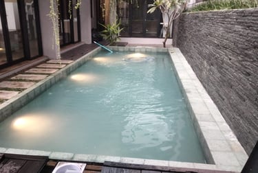 Kolam renang pribadi di malam hari dengan pencahayaan LED yang indah, menciptakan suasana relaksasi.