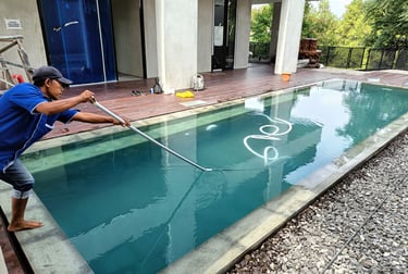 3.	Pekerja sedang membersihkan kolam renang dengan vakum.