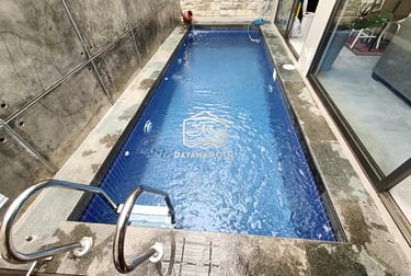 Kolam renang pribadi di malam hari dengan pencahayaan LED yang indah, menciptakan suasana relaksasi.