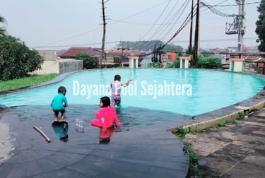 Anak-anak tertawa riang bermain di kolam renang, menggambarkan kebahagiaan keluarga.