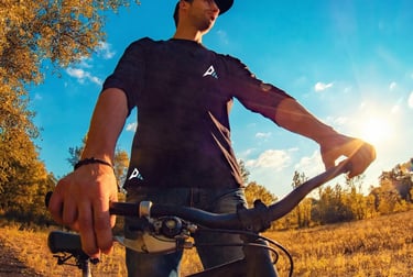 homme à vélo en forêt portant un vêtement technique  Ascentierra
