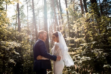 a bride and groom standing in a forest