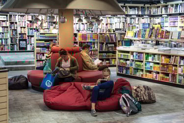 a woman sitting on a couch in a library
