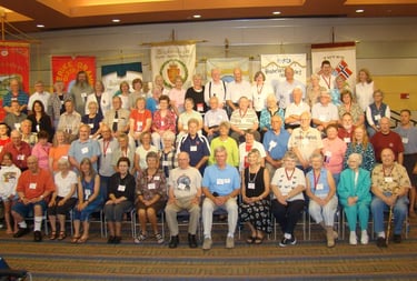 a larget group of lag members at a stevne posed in front of each lag's fane