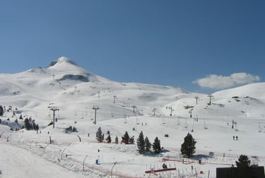 a ski slope with a ski lift in the background