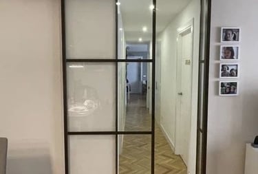 Puerta de interior corredera de una hoja en hierro con cuarterones.