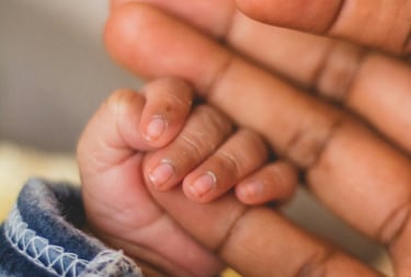 Baby hand grasping hold of parents little finger