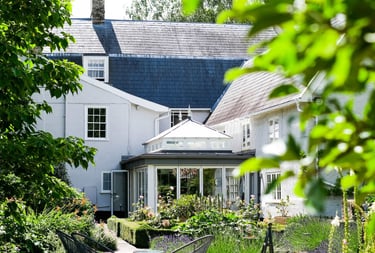 Exterior view of a classic orangery extension designed to connect the home and garden in Suffolk.
