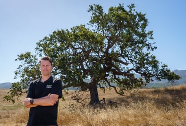 Caregiver Clint Fultz standing in front of an oak tree in Thousand Oaks, California.