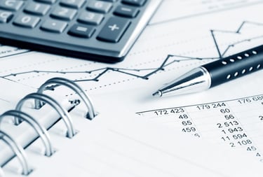 Financial records and calculator showing organized monthly bookkeeping and expense tracking