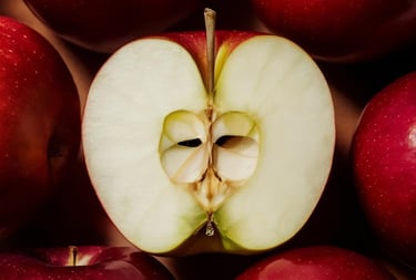 Fresh red apples with one sliced open showing the white core and seeds.