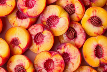 A colorful top-down view of fresh sliced peaches showing yellow flesh and red pits.