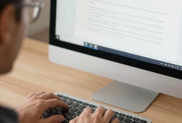 Close-up of hands typing on a laptop with multiple screens showing data analysis and case files.