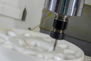 Automated CNC milling machine precision cutting a white plastic industrial component.