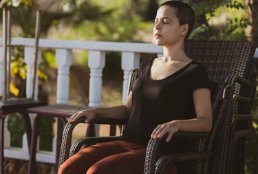 a woman sitting on a chair with her eyes closed