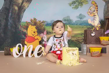 a baby girl in a pink dress and pink balloons